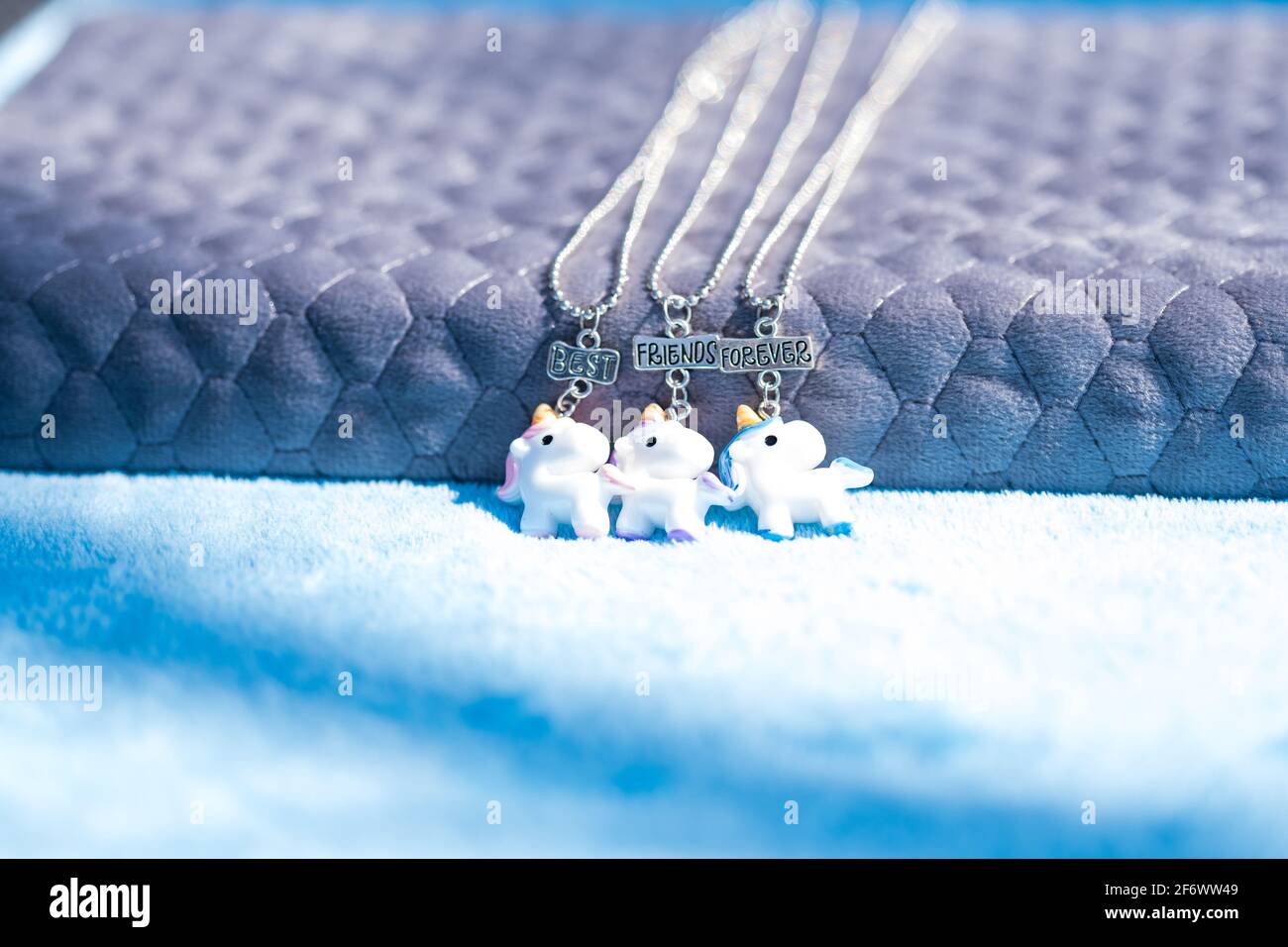 Set pendente di migliori amici per sempre tre girocollo unicorni sparare all'esterno in un closeup di giorno d'estate. Messa a fuoco selettiva Foto Stock