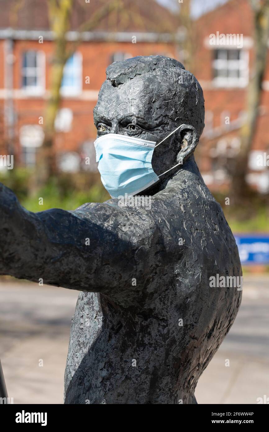 Statua di un uomo che indossa una maschera medica blu durante la pandemia di Coronavirus Covid-19 - una delle due figure della scultura l'Arc. Basingstoke, Regno Unito Foto Stock