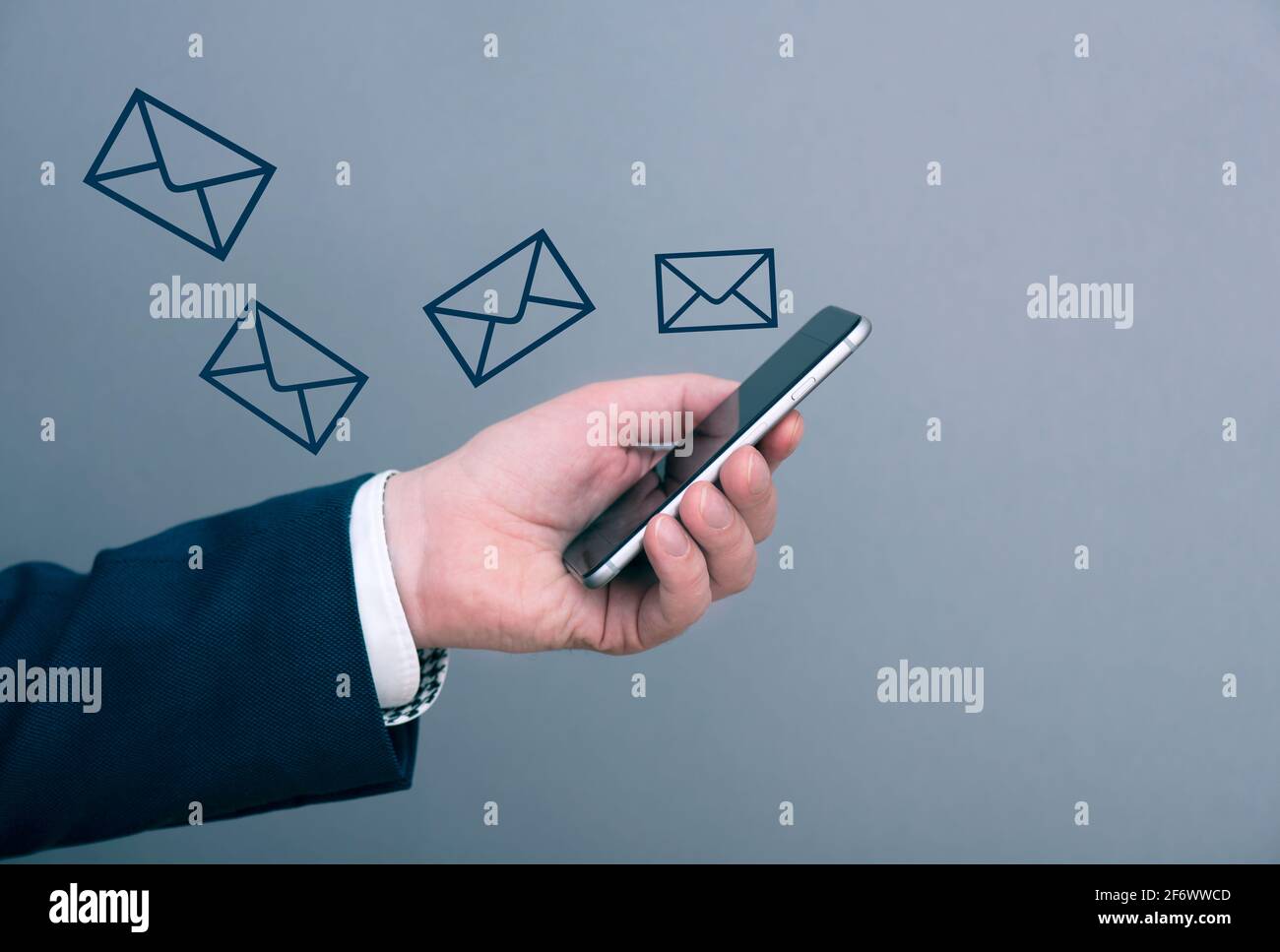 Un uomo d'affari che riceve molti nuovi messaggi, e-mail al telefono. Uomo che tiene il telefono. Immagine del concetto di business. Foto Stock
