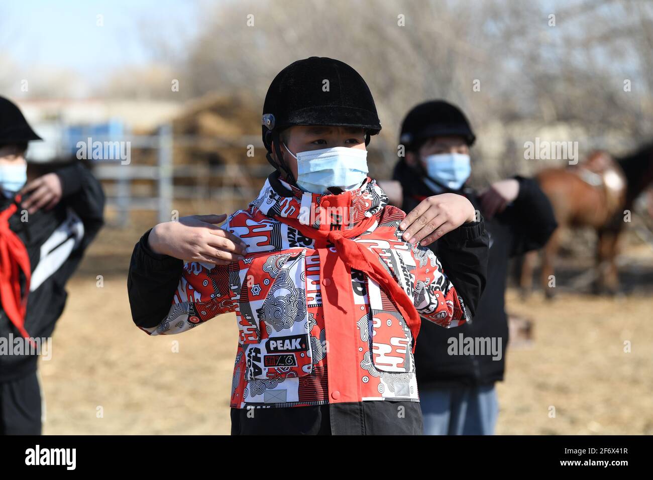 (210403) -- BURQIN, 3 aprile 2021 (Xinhua) -- Parasat Zhumabek, uno studente di grado senventesimo della Oymak Boarding School, si riscalda durante una classe equestre nella contea di Burqin, nella regione autonoma di Xinjiang Uygur, 30 marzo 2021. La gente nella regione autonoma di Xinjiang Uygur ha una tradizione di allevamento di cavalli e di equitazione. La scuola di imbarco di Oymak ha cominciato ad offrire le classi equestri alla fine del 2019. Gli studenti, la maggior parte dei quali provengono da famiglie di pastori, imparano sia la conoscenza teorica che la pratica di equitazione sulle classi equestri. Dopo le lezioni, gli studenti si rafforzano fisicamente e amano Foto Stock