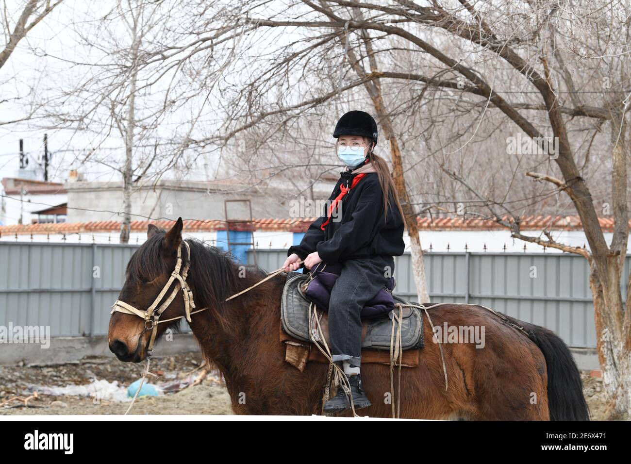 (210403) -- BURQIN, 3 aprile 2021 (Xinhua) -- Parizat Jinges, un allievo di grado senventesimo della scuola di imbarco di Oymak, cavalca su un cavallo durante una classe equestre nella contea di Burqin, regione autonoma di Xinjiang Uygur della Cina nord-occidentale, 29 marzo 2021. La gente nella regione autonoma di Xinjiang Uygur ha una tradizione di allevamento di cavalli e di equitazione. La scuola di imbarco di Oymak ha cominciato ad offrire le classi equestri alla fine del 2019. Gli studenti, la maggior parte dei quali provengono da famiglie di pastori, imparano sia la conoscenza teorica che la pratica di equitazione sulle classi equestri. Dopo le lezioni, gli studenti si rafforzano fisicamente e lov Foto Stock