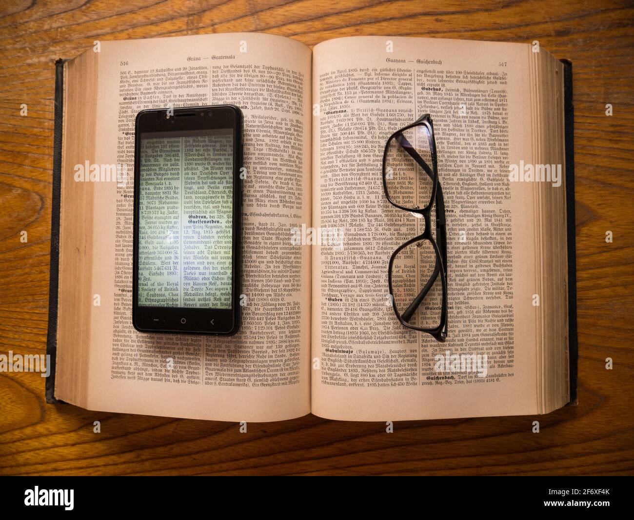 Occhiali e smartphone con una copia digitale di più di 100 anni di libro si trova sul originale. Foto Stock