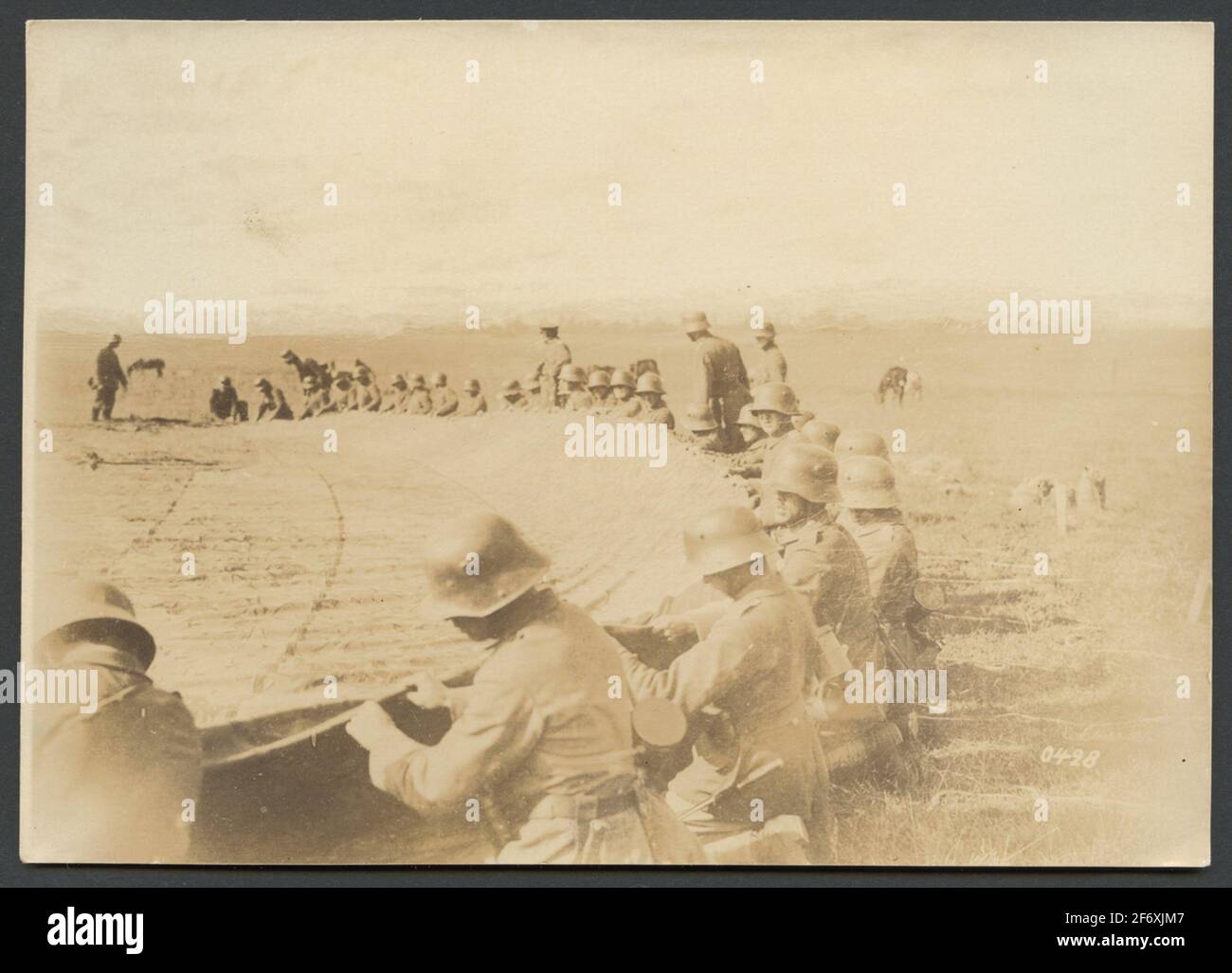 L'immagine mostra soldati con caschi in acciaio che lavorano con un grande pezzo di tessuto su un campo libero.dietro i soldati che lavorano sono diversi altri che sembrano fornire istruzioni. L'immagine mostra soldati con caschi in acciaio che lavorano con un grande pezzo di tessuto su un campo libero.dietro i soldati che lavorano sono diversi altri che sembrano fornire istruzioni. Foto Stock