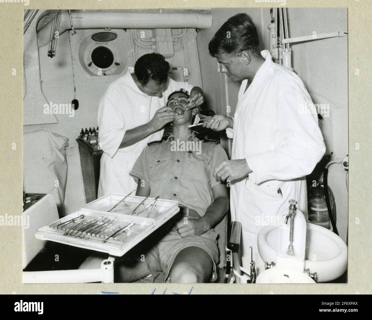 L'immagine rappresenta un membro dell'equipaggio che viene indagato dai dentisti in camici bianchi a bordo del fiume mincoat. La foto viene scattata durante il lungo viaggio 1966-1967 .. La foto rappresenta un membro dell'equipaggio che viene esaminato dai dentisti in camici bianchi a bordo del fiume mincoat. La foto viene scattata durante il lungo viaggio del 1966-1967. Inclusa negli album con fotografie del lungo viaggio di Älvsnabben 1966-1967. Ha declinato 10/11 1966 da Karlskrona e ha attraversato il canale di Suez per l'Australia, COSTA Ovest DEGLI STATI UNITI, attraverso il canale di Panama via Dublino che ospita Marstrand 6/5 1967. L'album contiene immagini Foto Stock
