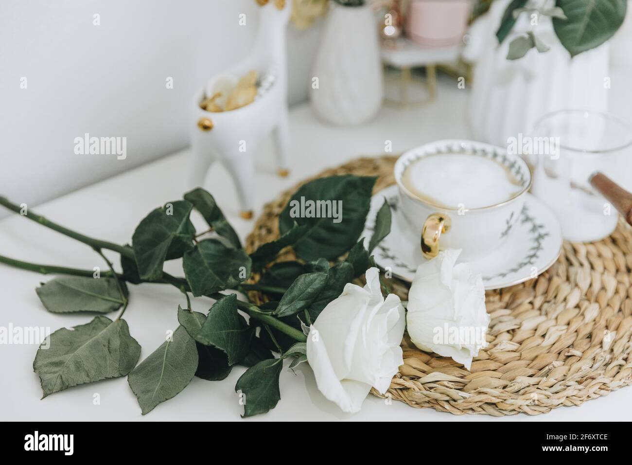 Tazza di caffè e rose bianche su un tavolo Foto Stock