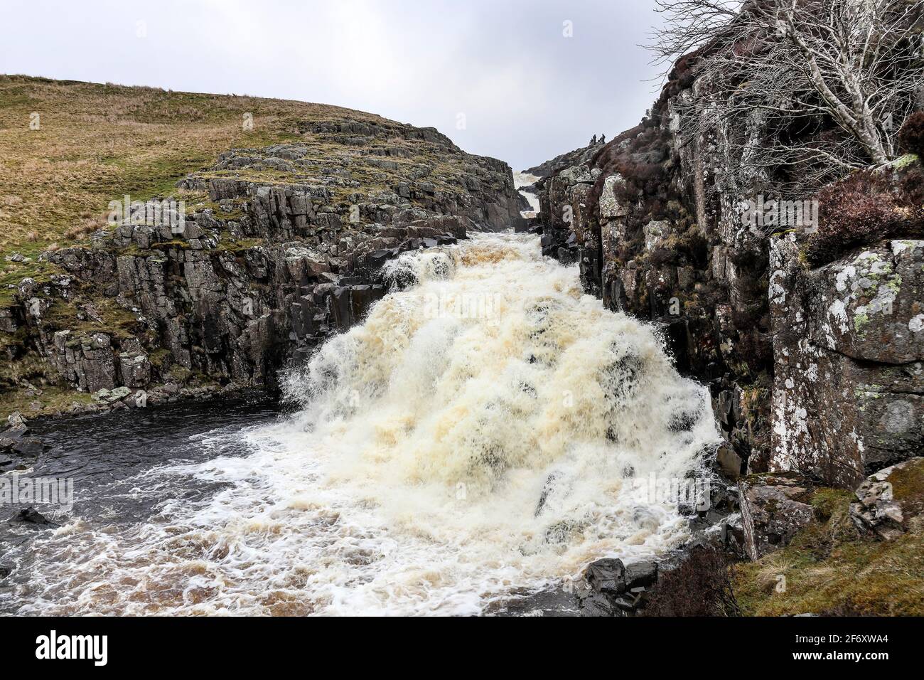 Un gruppo di persone che si levano in piedi sullo Skyline sono dwarfed dalle cascate di Cauldron Snout, Upper Teesdale, County Durham, UK Foto Stock