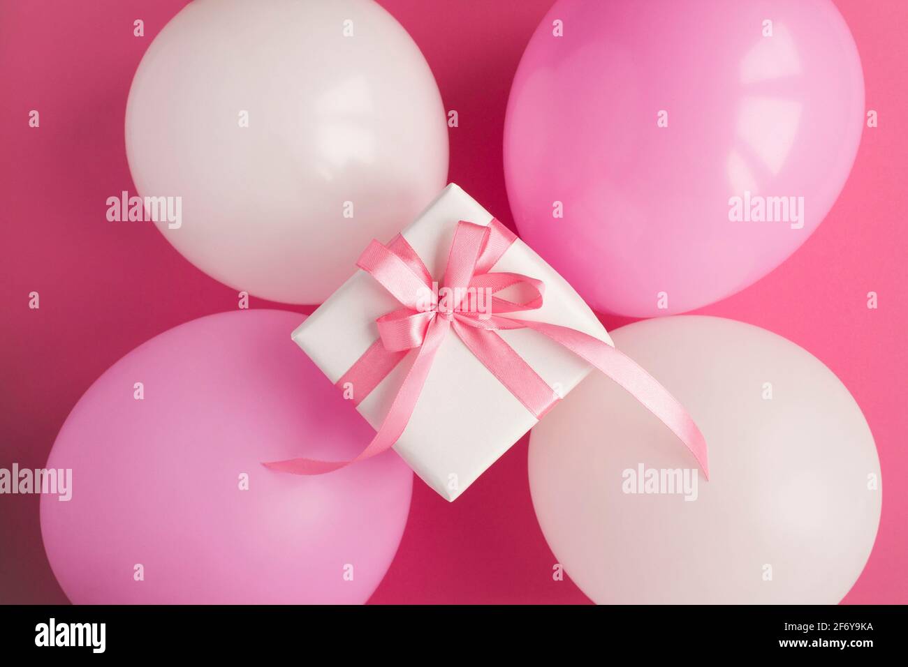 Regalo con palloncini rosa e bianchi su sfondo rosa. Vista dall'alto. Primo  piano Foto stock - Alamy