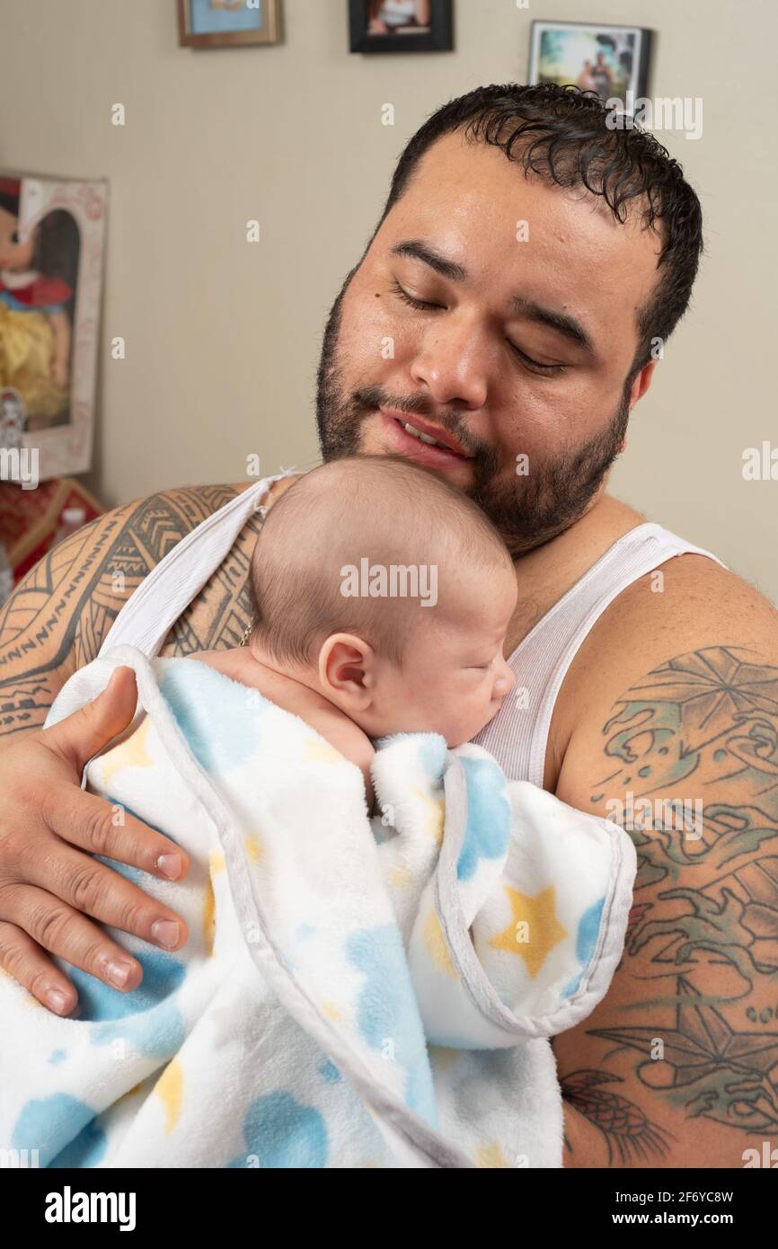 Neonato bambino ragazzo 7 settimane di sonno tenuto da padre Foto Stock