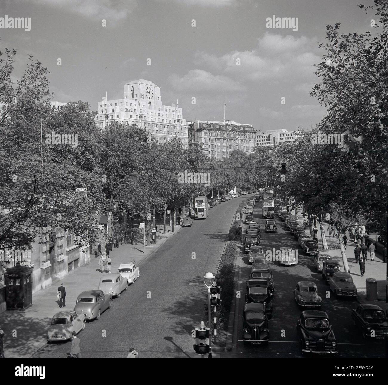 Anni '50, vista storica dall'alto che guarda lungo il Victoria Embankment, con il lato sud dell'edificio in stile Art Deco, Shell Mex House in lontananza, Londra, Inghilterra, Regno Unito. Si dice che il suo famoso orologio abbia la faccia più grande del Regno Unito. Una parte del Tamigi Embankment, la strada e la bella passeggiata alberata lungo il fiume sulla riva nord del Tamigi unisce il Palace of Westminster al Blackfairs Bridge nella città di Londra. Foto Stock