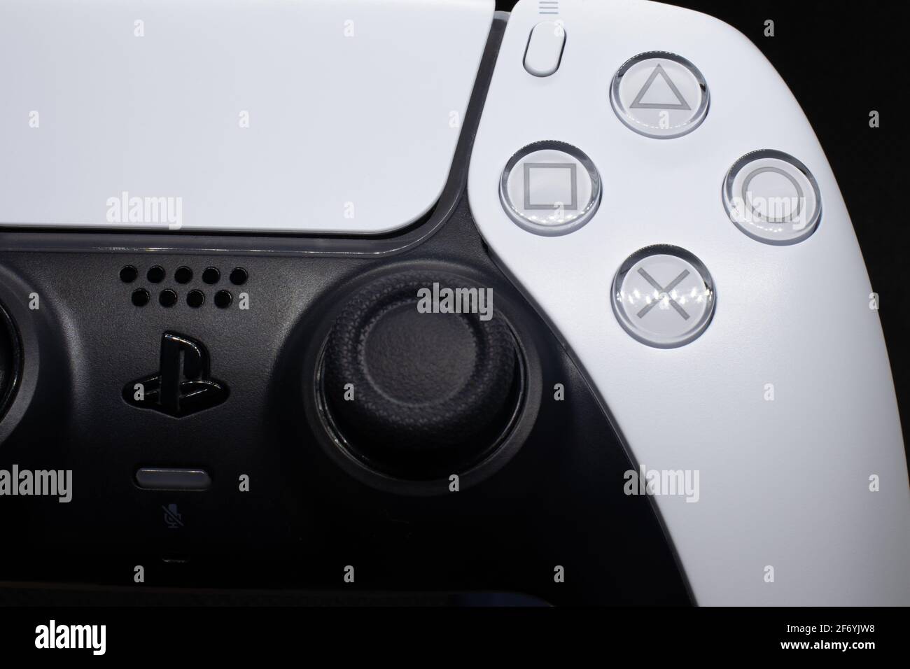 Il gamepad per PS5 si avvicina a luci e ombre. Controller playstation 5 bianco e nero con sfondo scuro con dettagli del logo e pulsante macro. Foto Stock