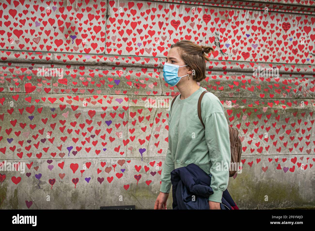 WESTMINSTER LONDON, REGNO UNITO 3 APRILE 2021. I membri della vista pubblica i cuori rossi creati per conto delle famiglie in covidio per la giustizia al National Covid Memorial Wall lungo l'argine del Tamigi di fronte all'edificio del Parlamento. Ogni cuore rappresenta una vita persa per la pandemia del coronavirus nel Regno Unito che ha superato 126,000 vite fino ad oggi. Credit amer Ghazzal/Alamy Live News Foto Stock