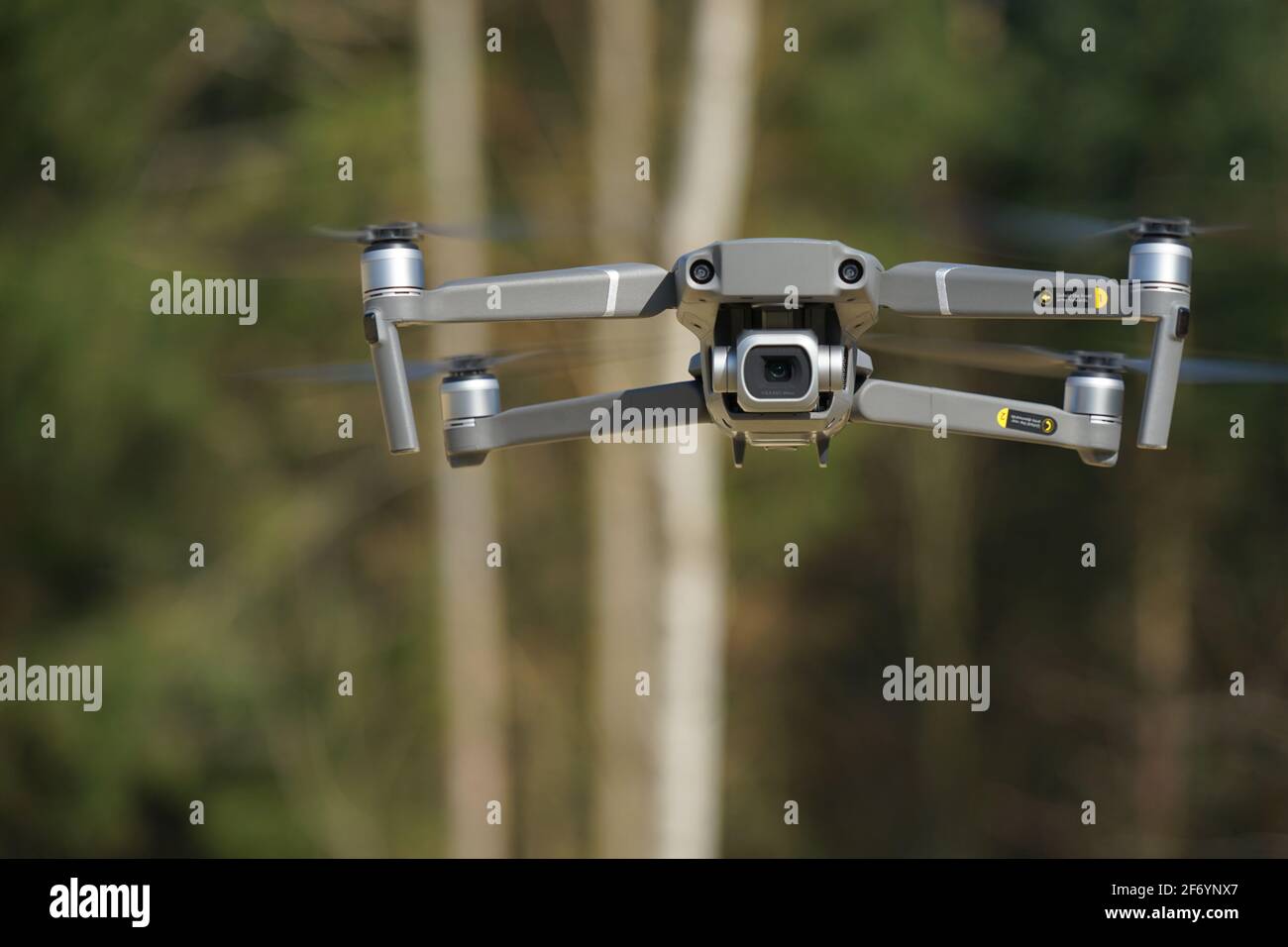 Fotocamera drone in volo prima di uno sfondo di foresta Foto Stock