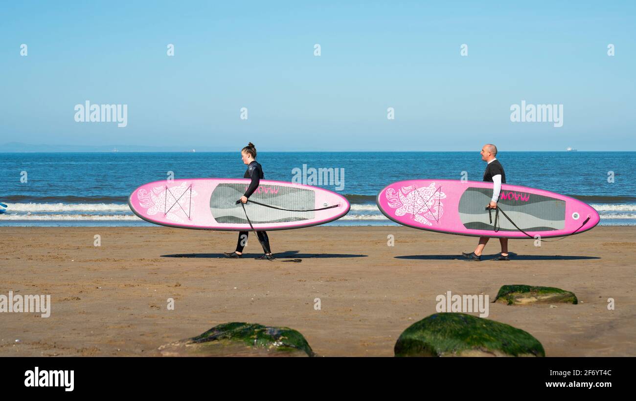 Portobello, Scozia, Regno Unito. 3 aprile 2021. Le folle del fine settimana di Pasqua scendono sulla spiaggia e sul lungomare di Portobello per sfruttare al massimo le restrizioni di viaggio Covid-19, appena rilassate, e il caldo sole con cieli blu ininterrotti. PIC; la famiglia Sturgeon di Edimburgo ha fatto il massimo delle onde modeste per andare a surf. Iain Masterton/Alamy Live News Foto Stock