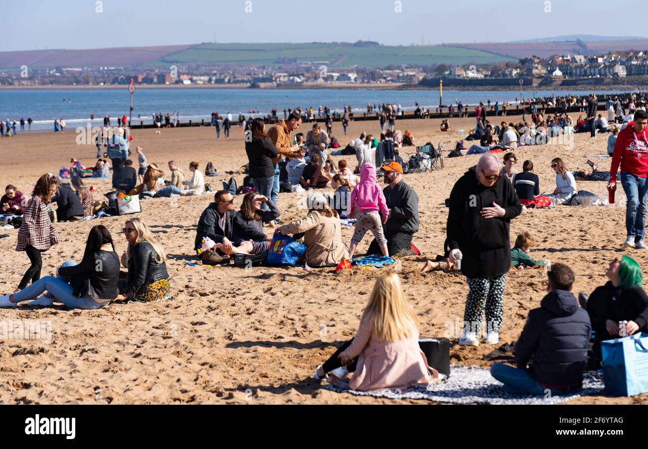 Portobello, Scozia, Regno Unito. 3 aprile 2021. Le folle del fine settimana di Pasqua scendono sulla spiaggia e sul lungomare di Portobello per sfruttare al massimo le restrizioni di viaggio Covid-19, appena rilassate, e il caldo sole con cieli blu ininterrotti. PIC; Spiaggia occupata con i membri del pubblico in piccoli gruppi. Iain Masterton/Alamy Live News Foto Stock