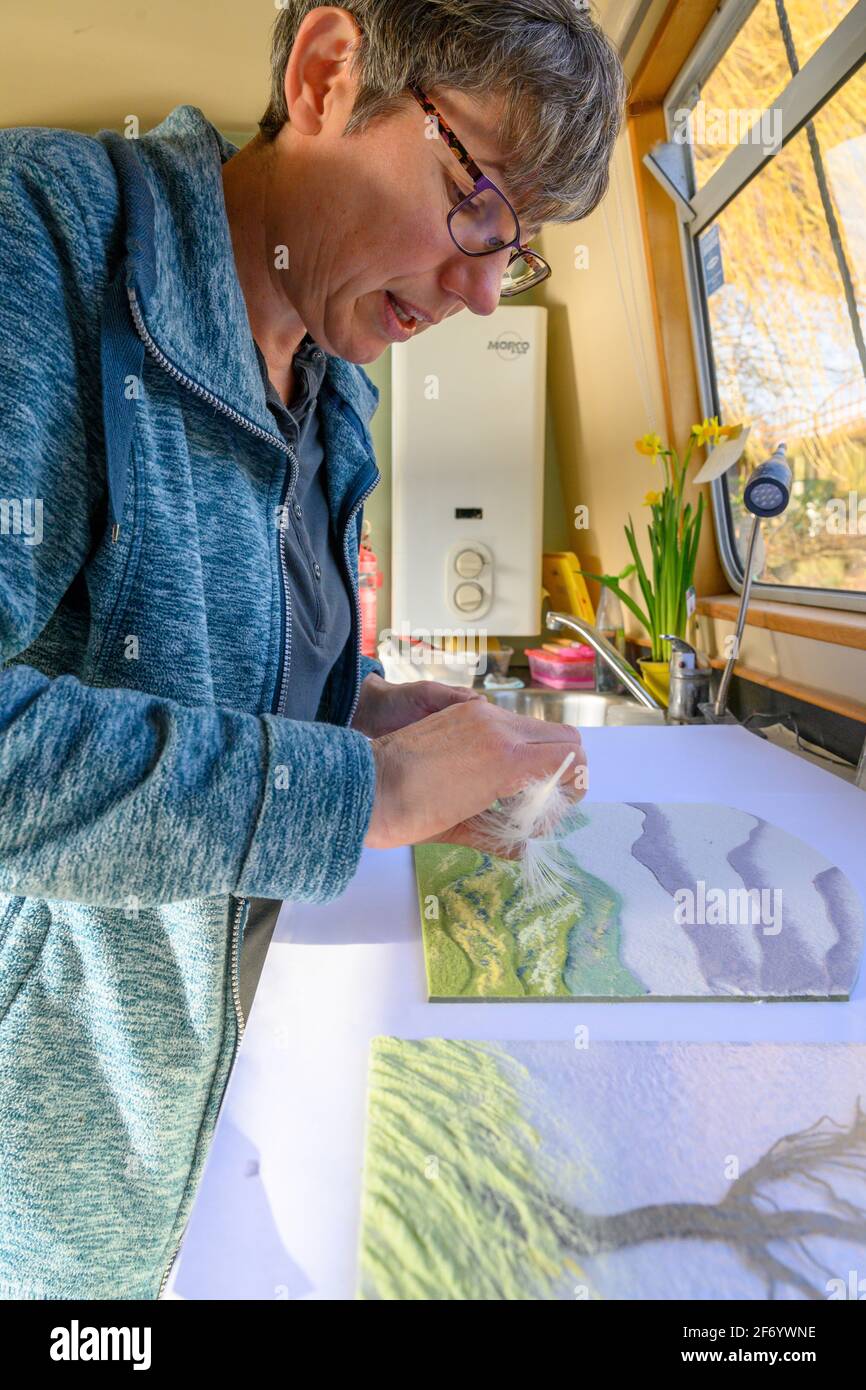 L'artista del vetro Katherine Webley lavora nel suo studio narrowboat, il Pod, realizzando prodotti di arte del vetro. Foto Stock