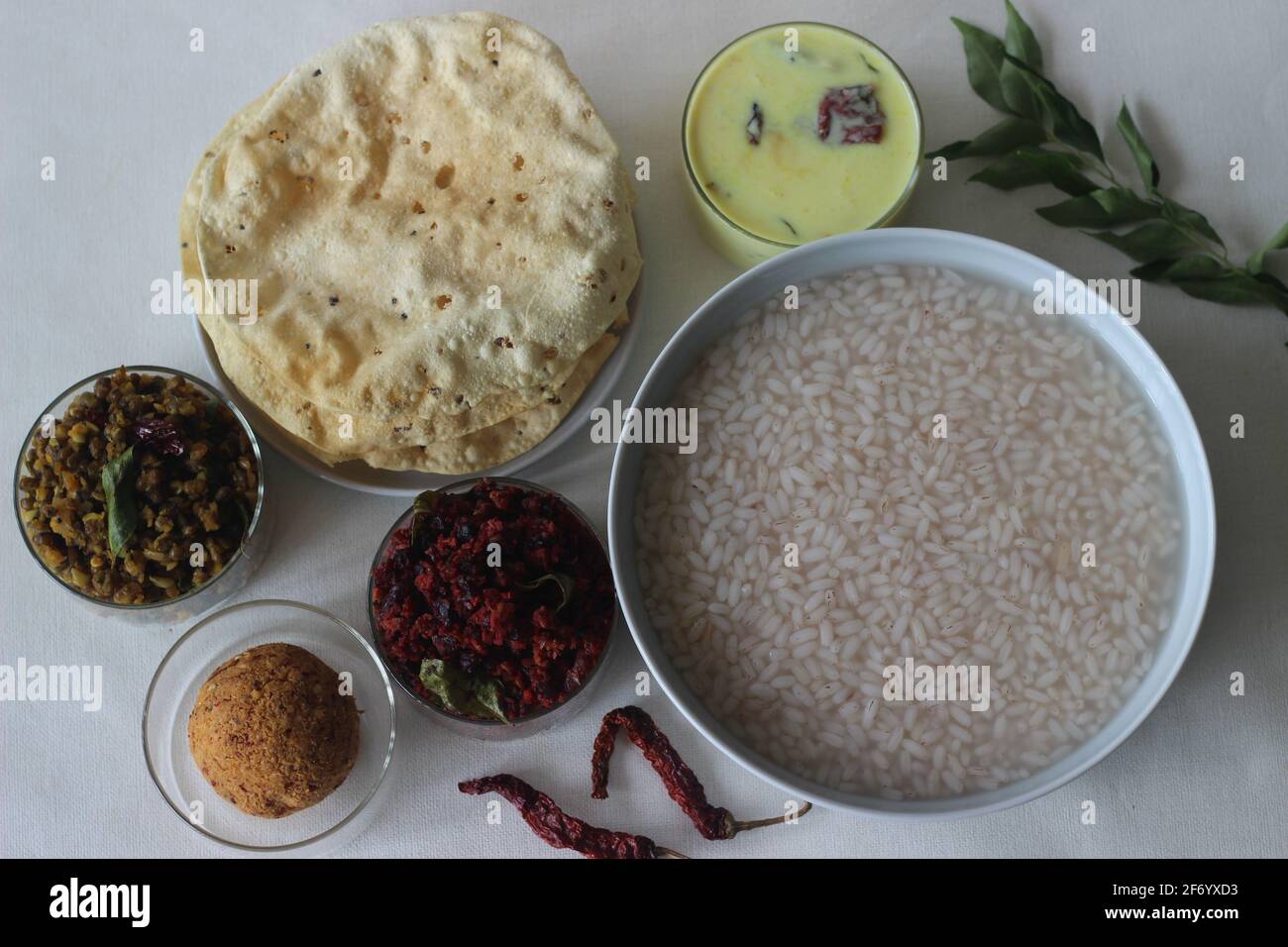 Porridge di riso o Kanji insieme al chutney di cocco, il toro di patate di barbabietola, moong fritto mescolato, papad fritto e latticello temperato. Un pasto preferito di Foto Stock