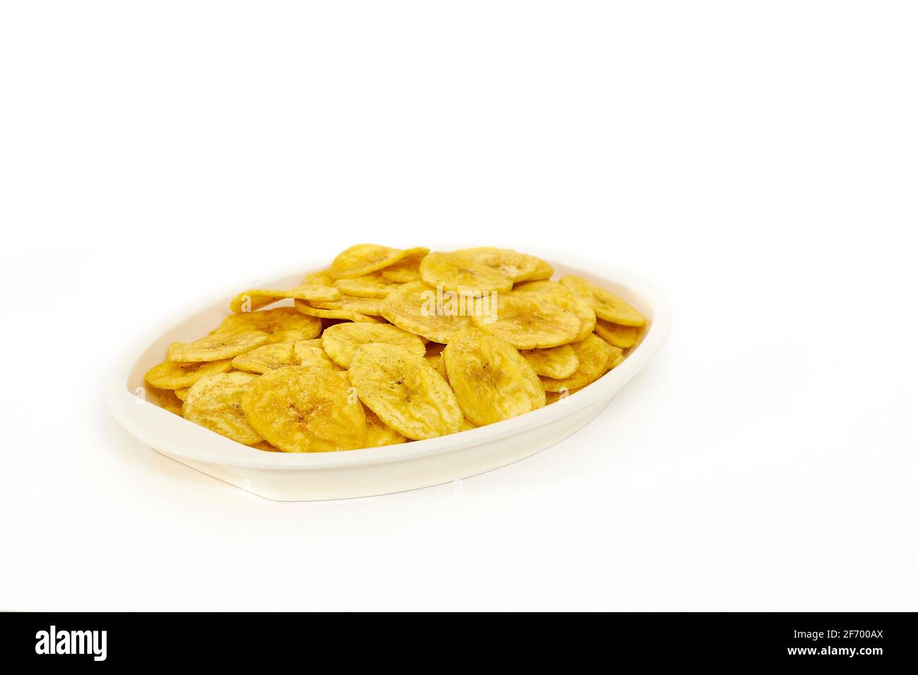 Patatine di banana in un recipiente da portata su sfondo bianco Foto Stock