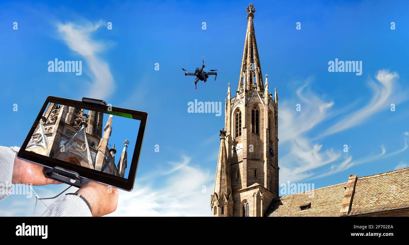 Drone in aria ispezionando torre della chiesa e ornamenti. Primo piano del display con decorazioni difettose Foto Stock