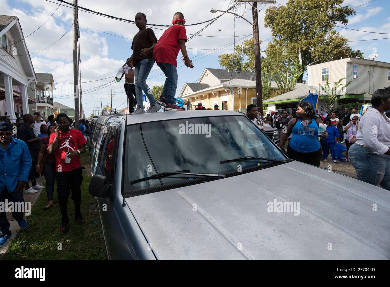 I bambini ballano sulle automobili durante la sfilata domenicale di Prince of Wales, New Orleans Social Aid e Pleasure Club Second Line (Secondline), New Orleans. Foto Stock