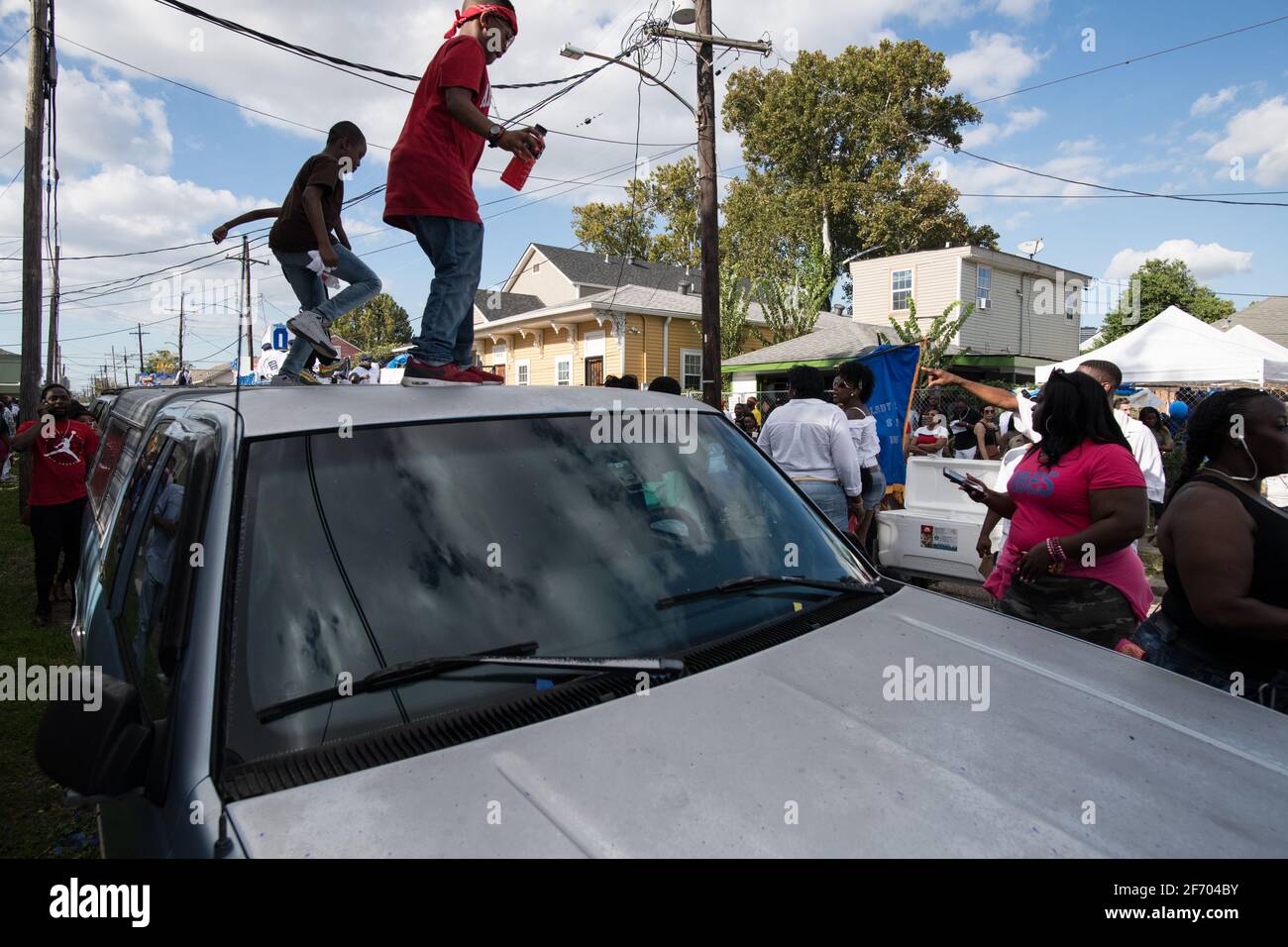 I bambini ballano sulle automobili durante la sfilata domenicale di Prince of Wales, New Orleans Social Aid e Pleasure Club Second Line (Secondline), New Orleans. Foto Stock