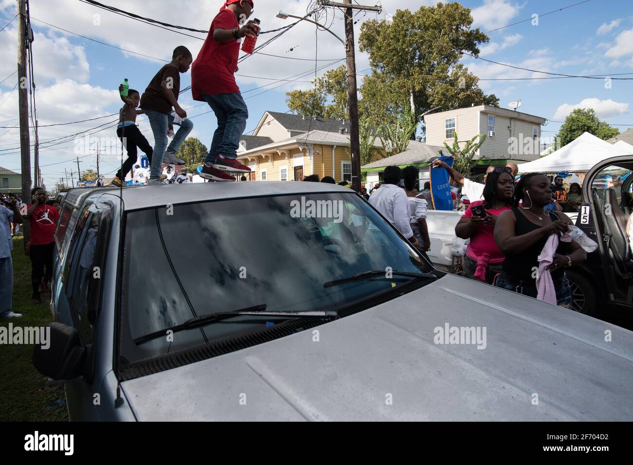 I bambini ballano sulle automobili durante la sfilata domenicale di Prince of Wales, New Orleans Social Aid e Pleasure Club Second Line (Secondline), New Orleans. Foto Stock