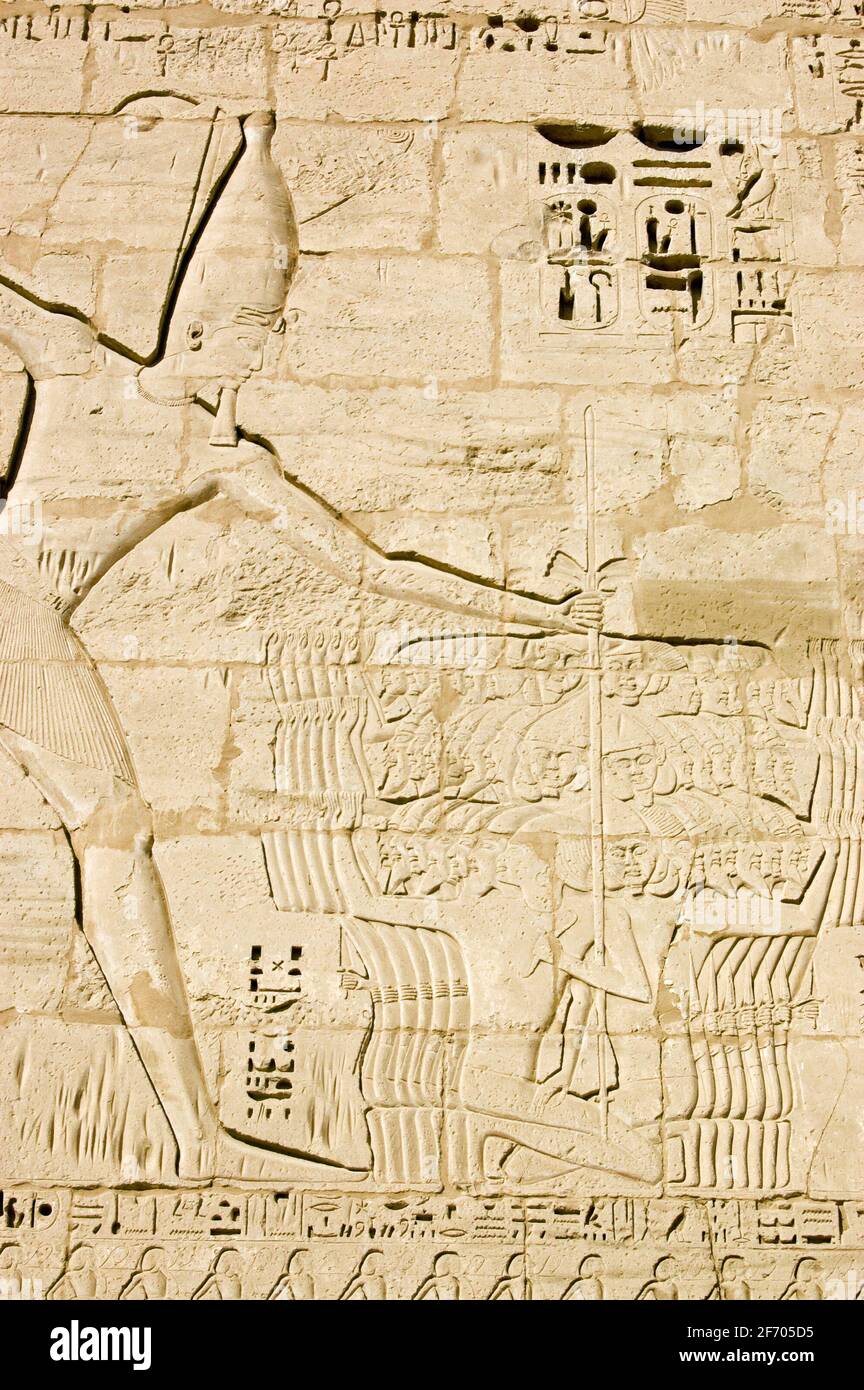 Un'enorme scultura geroglifica dell'antico faroah Ramses egiziano II tenendo un gruppo dei suoi nemici sconfitti con corde intorno al collo con una vista Foto Stock