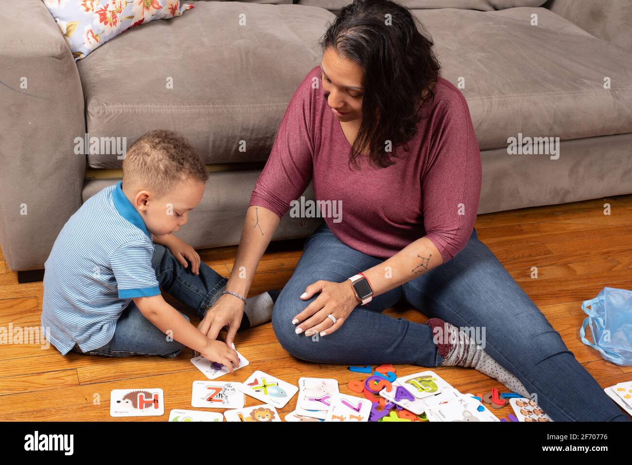 ragazzo di 3 anni con la madre, giocando con alfabeto e carte numeriche che hanno un pezzo di puzzle che si inserisce all'interno della carta di apprendimento a casa Foto Stock