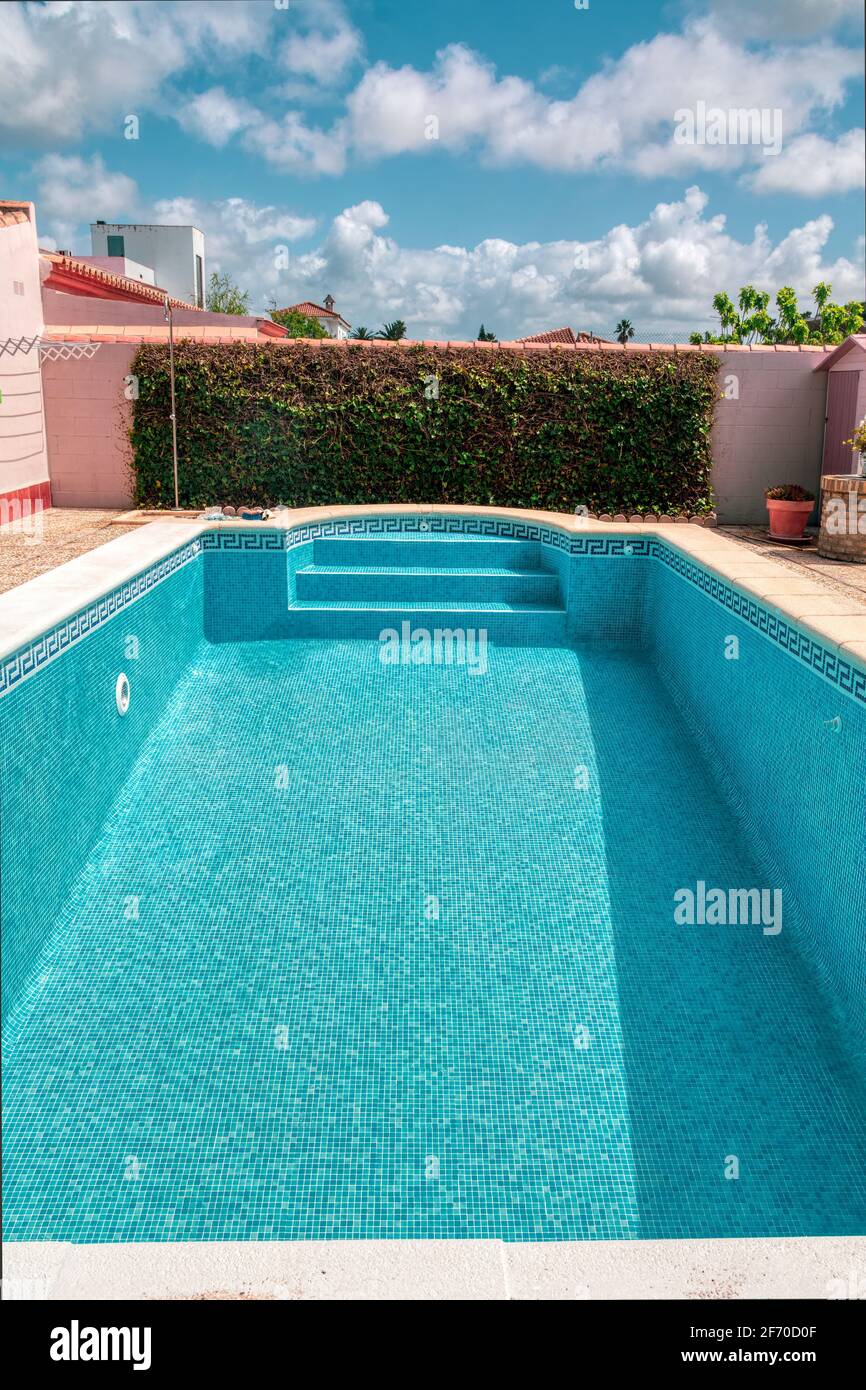 Piscina vuota con piastrelle blu Foto Stock