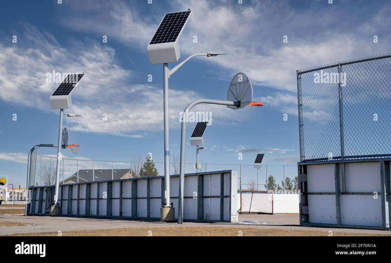 Le luci di strada alimentate a energia solare si ricaricano nella luce del giorno in un campo ricreativo all'aperto ad Airdrie Alberta Canada. Foto Stock