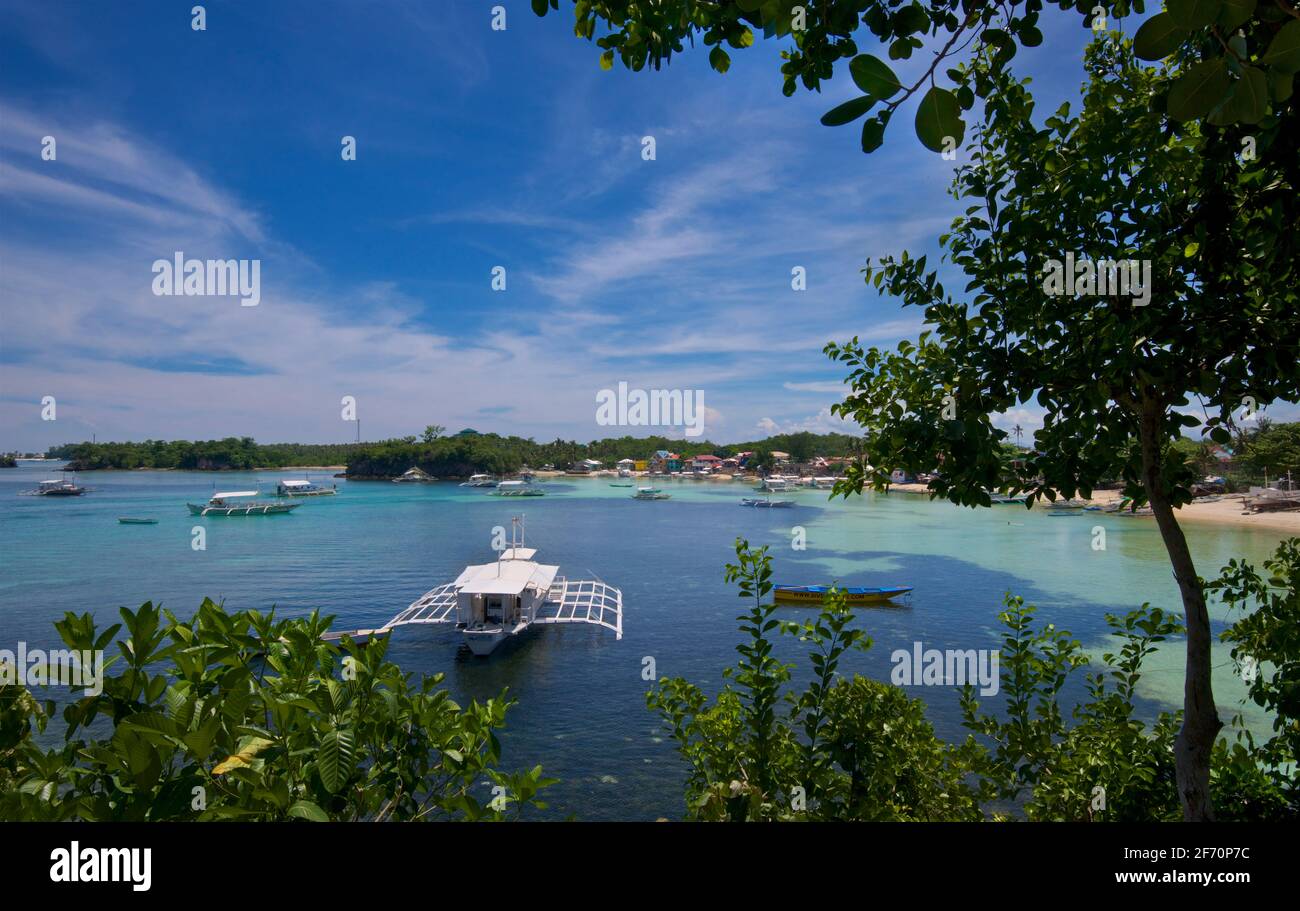 Logon, Malapascua Island, con barche locali ormeggiate nella baia. Mare di Visayan, Cebu, Filippine. Foto Stock