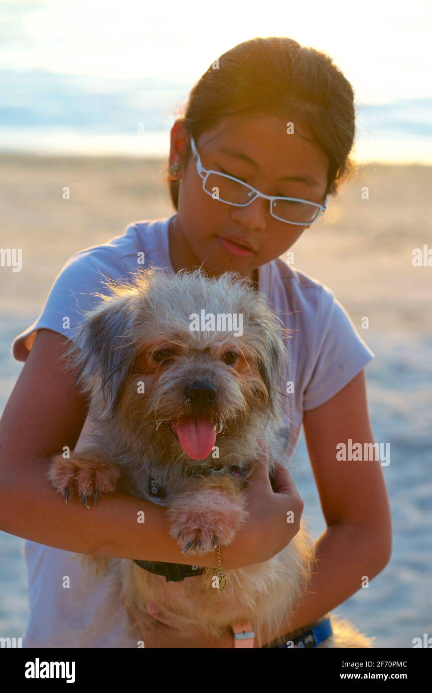 Ritratto di un cane da compagnia con il suo giovane proprietario. Isola di Malapascua, Cebu, Filippine. Foto Stock