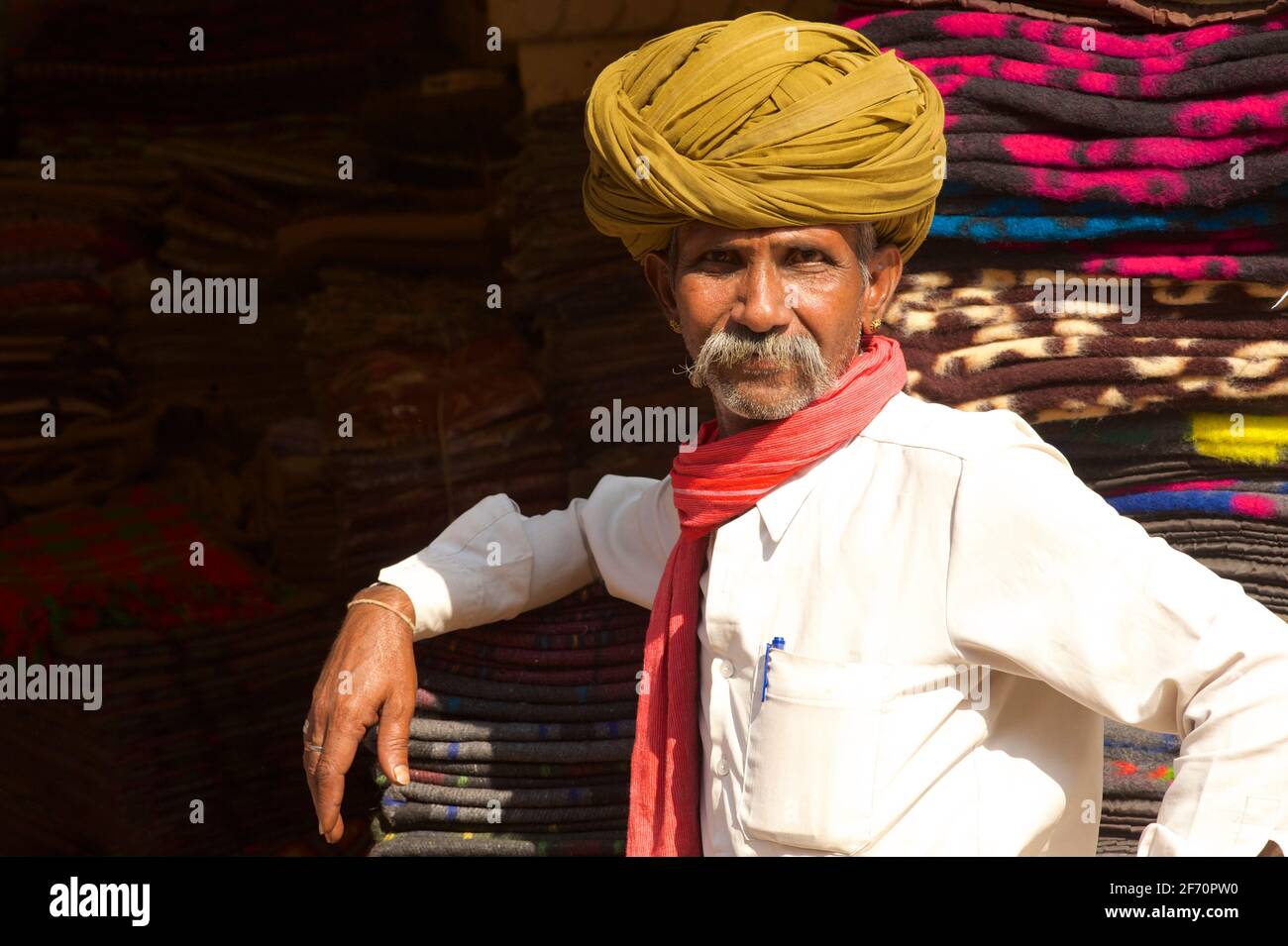 Ritratto di un venditore tessile Rajasthani in camicia bianca e turbante, Pushkar, Rajasthan, India Foto Stock