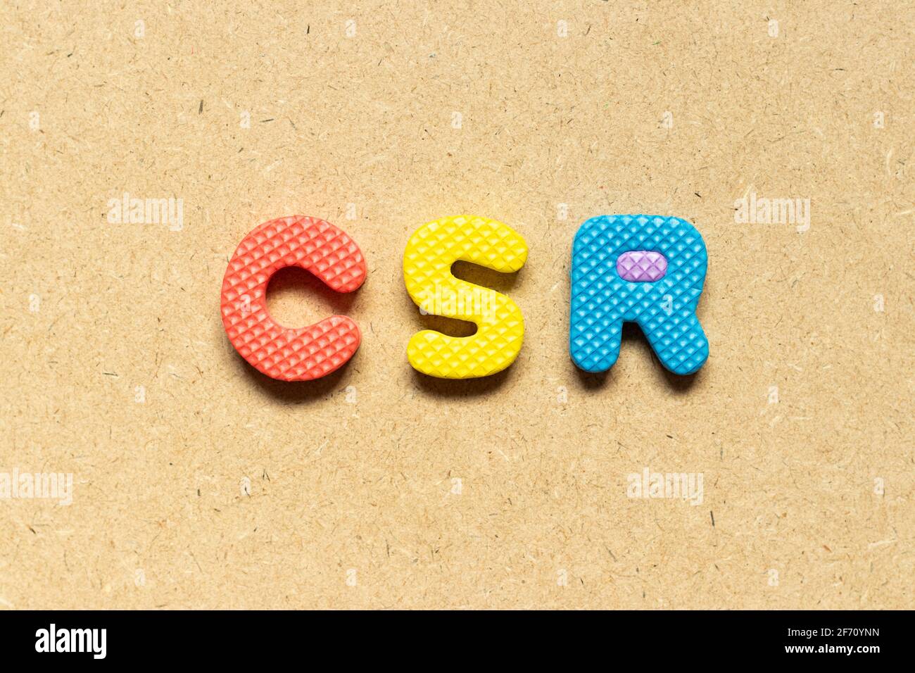 Lettera alfabetica in schiuma in parola CSR (Abbreviazione di responsabilità sociale d'impresa) su sfondo di legno Foto Stock
