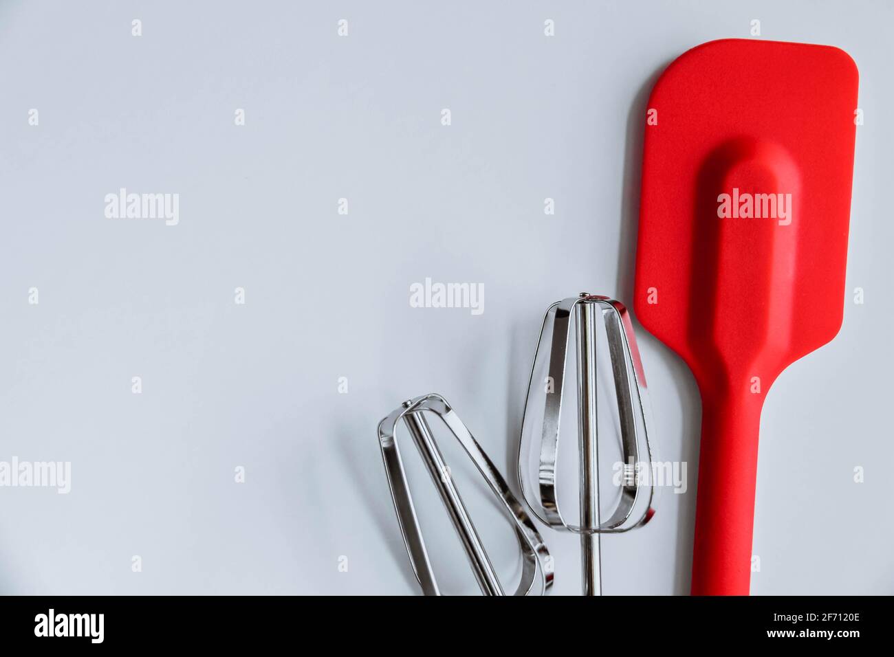 Fornitura di cottura su sfondo bianco. Spatola, mixer sbatte su sfondo bianco Foto Stock