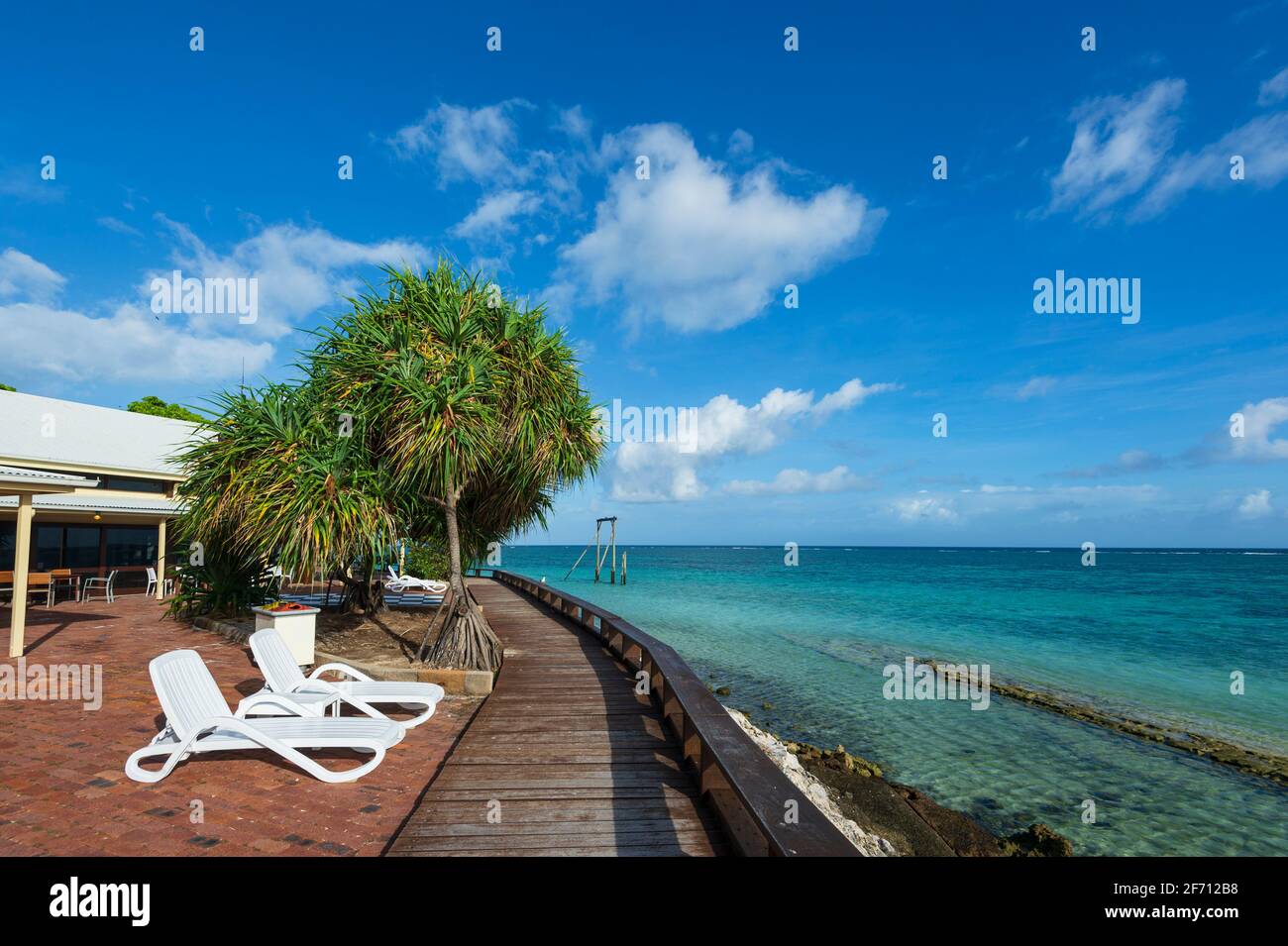 Sedie a sdraio che si affacciano sulle acque turchesi di Heron Island, Southern Great Barrier Reef, Queensland, QLD, Australia Foto Stock