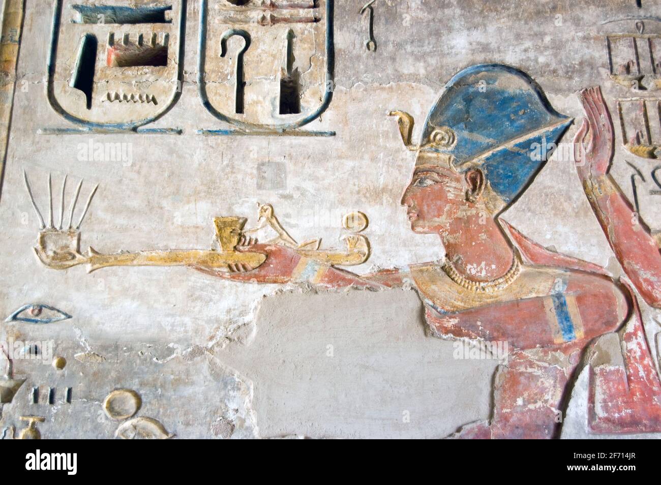 Una scultura hieroglyphic colorata splendidamente conservata del faroah Ramses II che tiene una lampada. Antica immagine egiziana su un muro al Tempio di Med Foto Stock