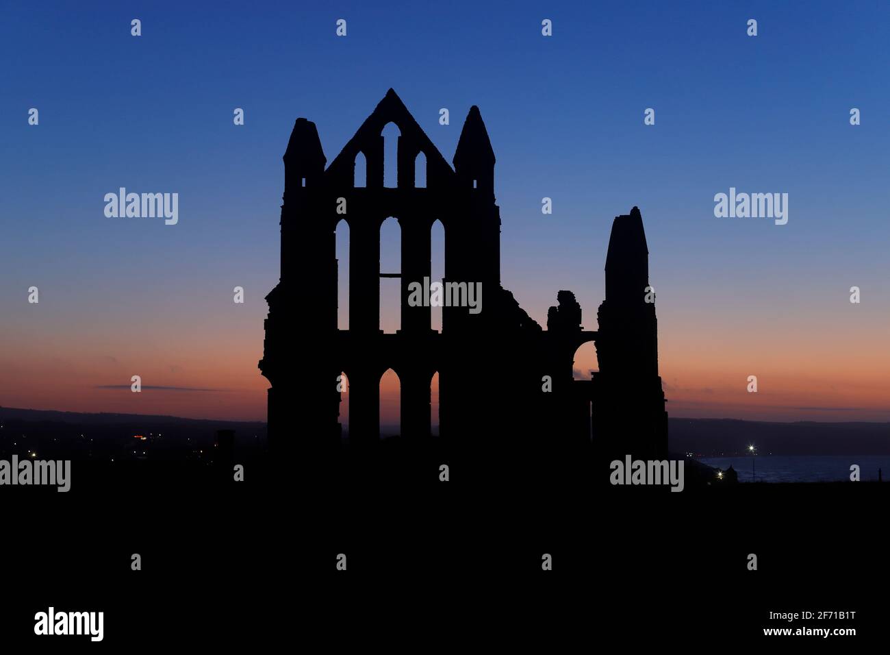 Whitby Abbey silhouette al tramonto a Whitby, North Yorkshire, UK Foto Stock