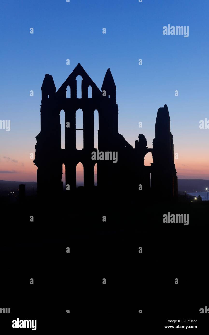 Whitby Abbey silhouette al tramonto a Whitby, North Yorkshire, UK Foto Stock