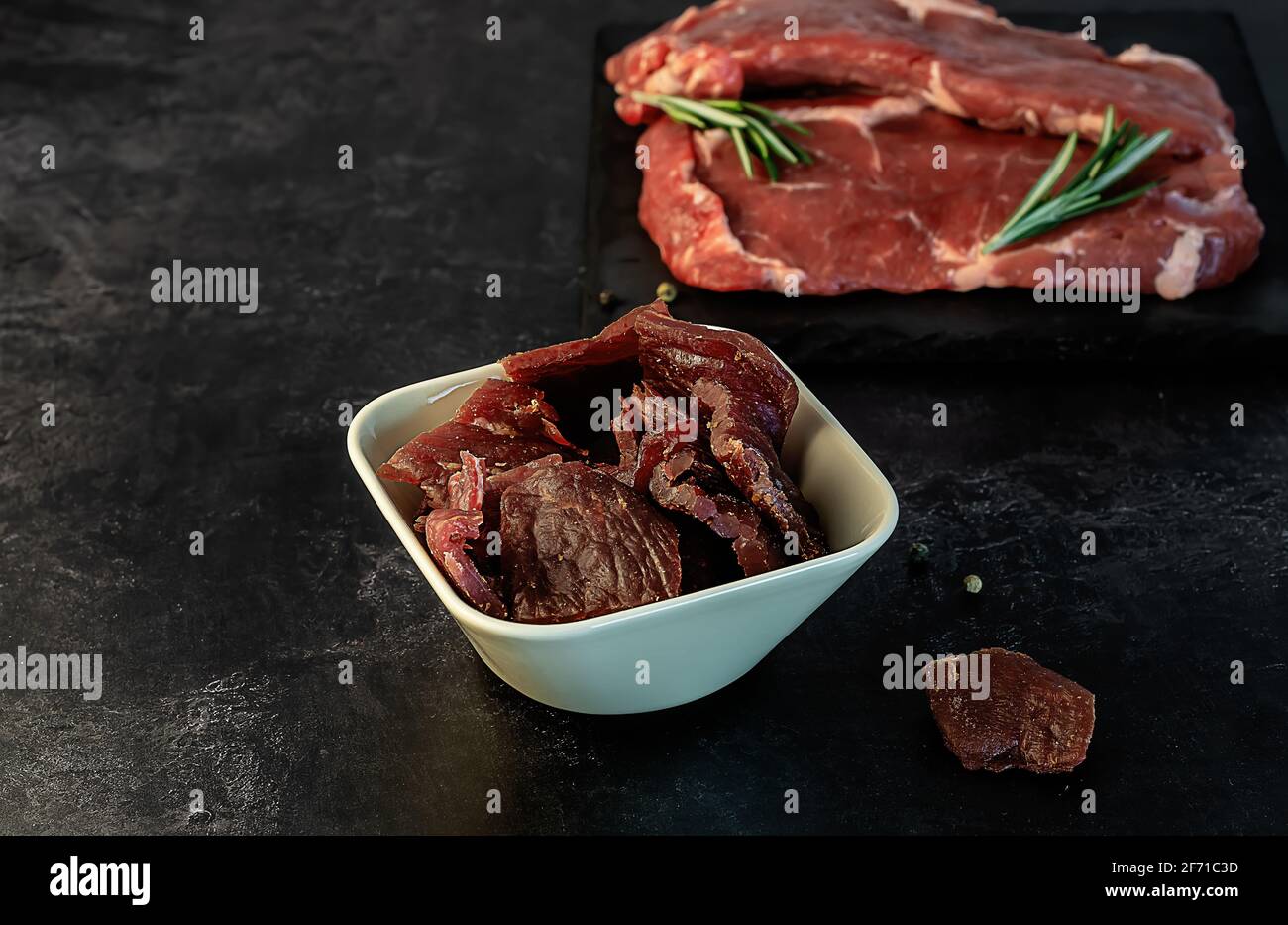 Spuntino a scatti con proteine di manzo magro. Affumicato, essiccato con tagli di carne e pepe. Foto Stock