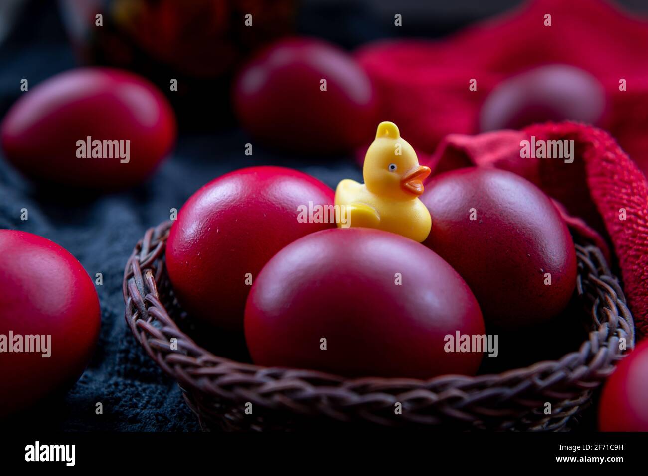 Un primo piano di uova di Pasqua in un cesto di vimini tinto nel tradizionale colore rosso. Foto Stock