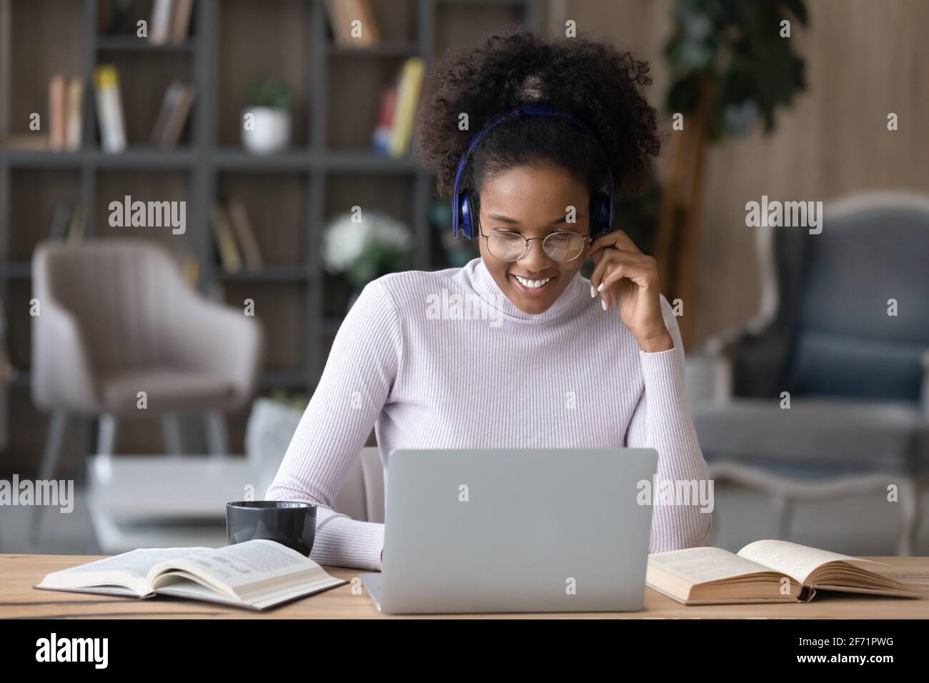 Felice Biracial femmina studentessa lontano sul portatile Foto Stock