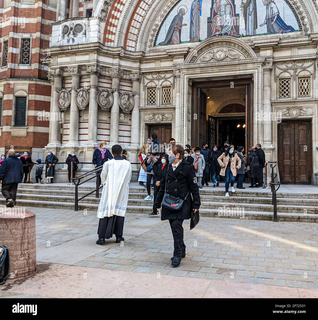 Londra, Regno Unito. 4th aprile 2021. Congregazione che esce dalla Cattedrale di Westminster, Londra, dopo la Messa della domenica di Pasqua del 10am celebrata dai cattolici romani. I Cappellani della Cattedrale salutano e benedicono i parrocchiani. Foto Stock