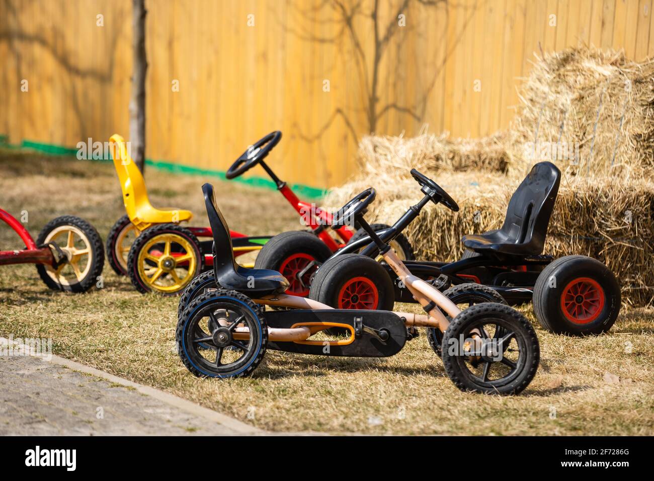 Biciclette per bambini parcheggiate presso la panchina del parco Foto Stock