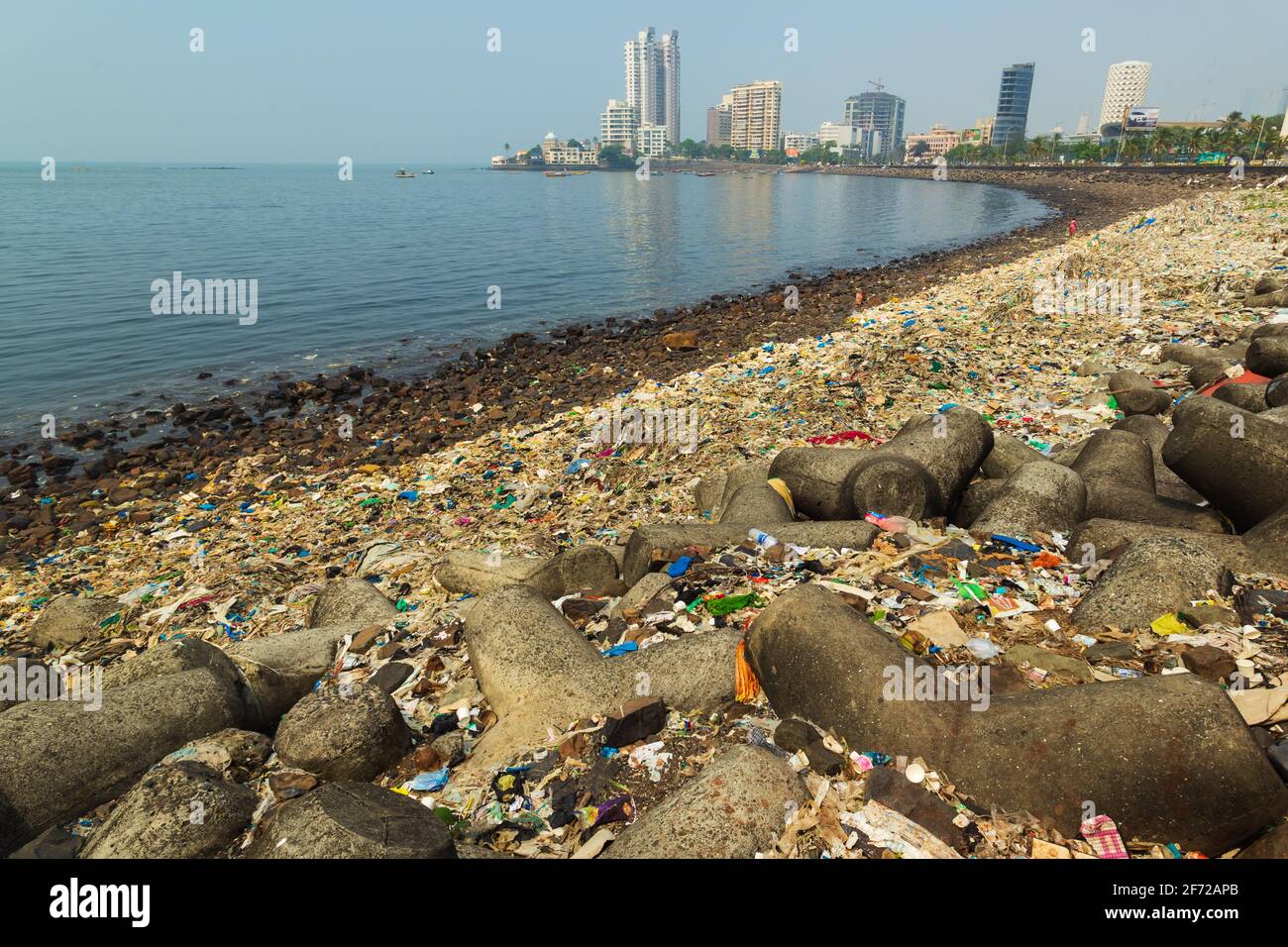 La costa di Mumbai è piena di rifiuti o di edifici urbani moderni in plastica sullo sfondo. Foto Stock