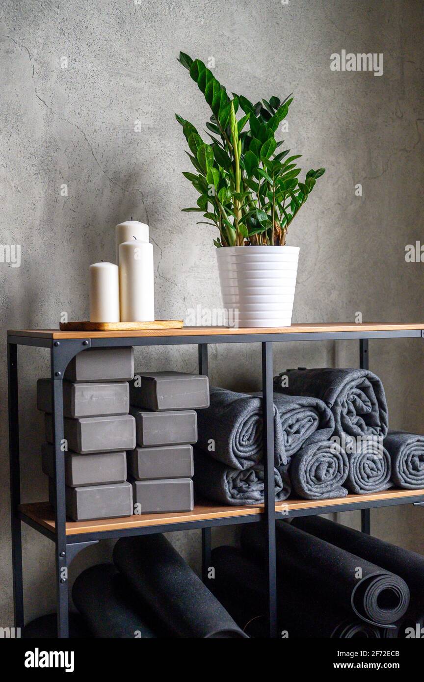 l'interno della sala è uno studio per lo yoga sportivo o lo stretching. tavolo con accessori per le lezioni - cubi di sostegno grigio, tappetini in gomma e plai Foto Stock