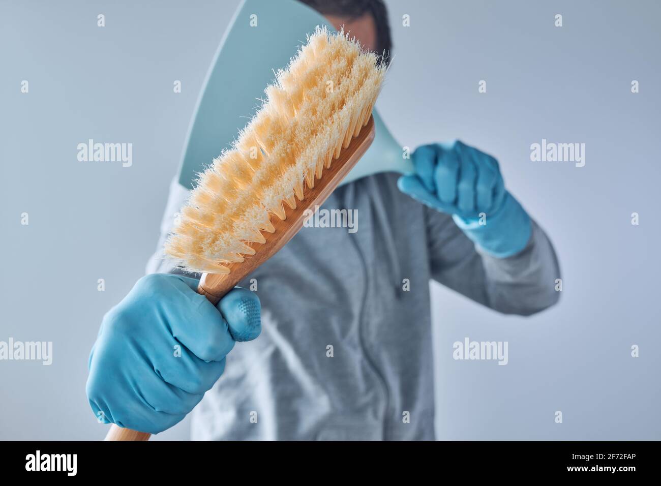 Pronto per la pulizia della casa, uomo con padella e spazzolina per la pulizia Foto Stock