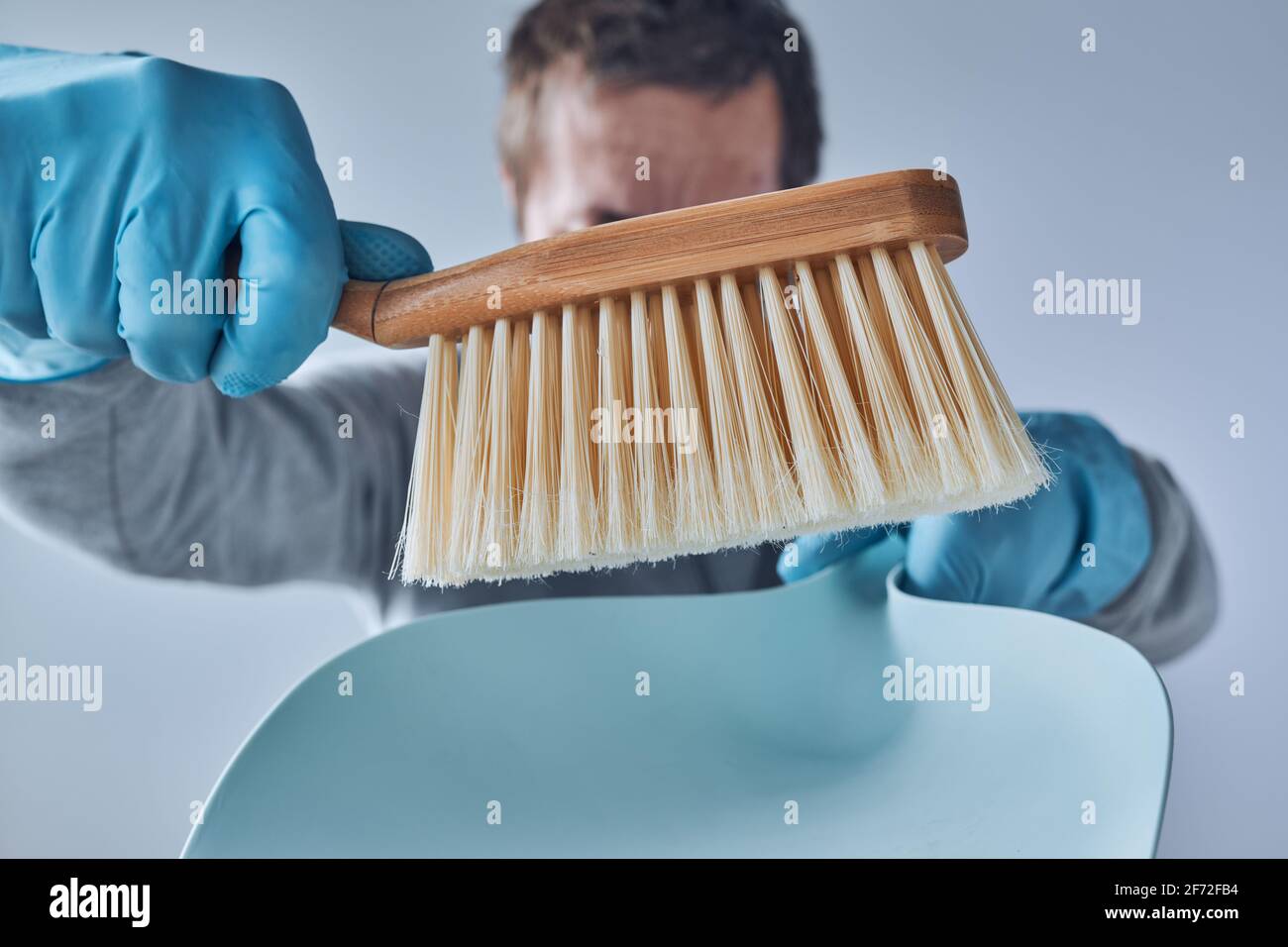 Pronto per la pulizia della casa, uomo con padella e spazzolina per la pulizia Foto Stock