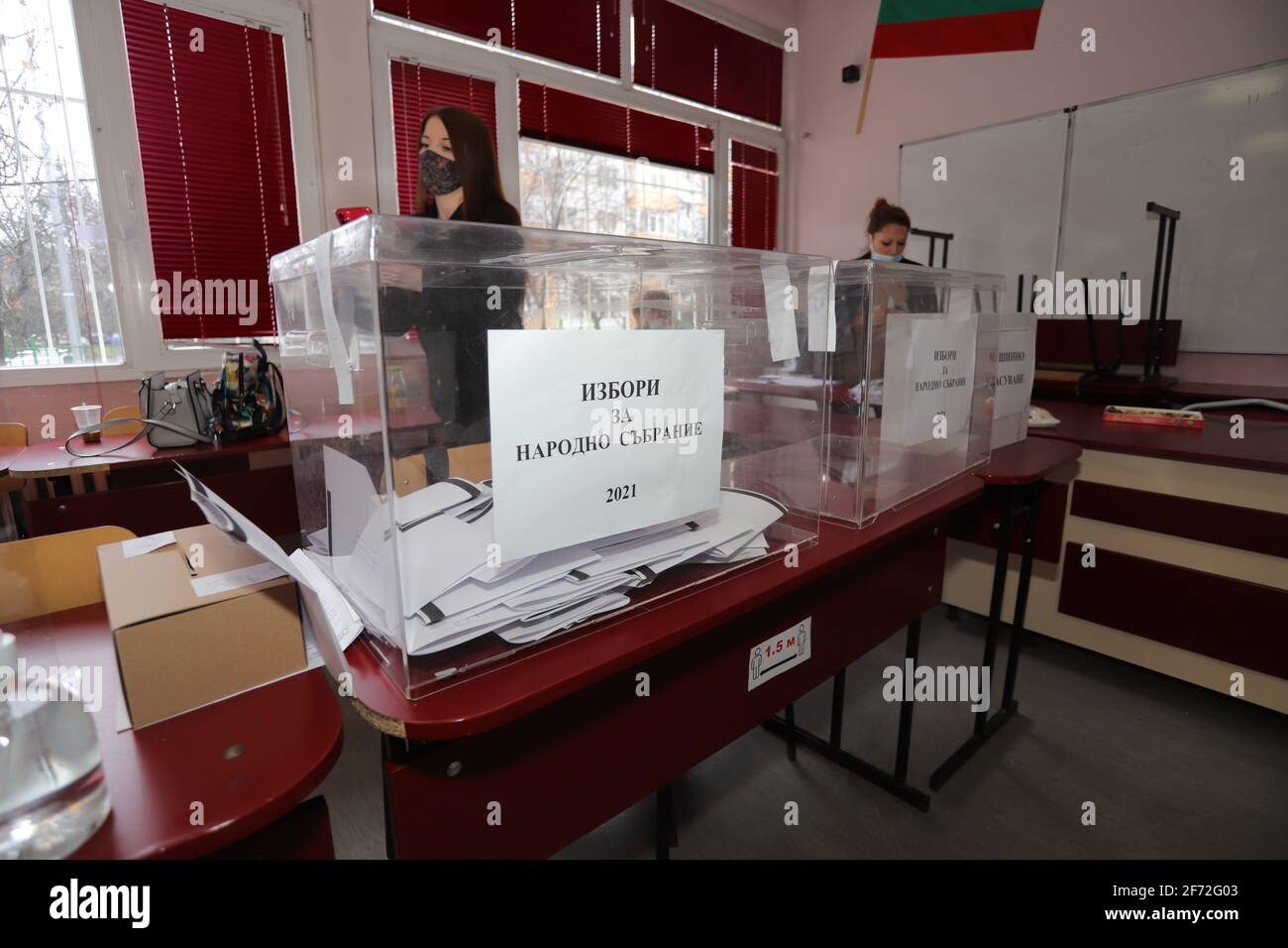 Le persone con maschere votano durante la pandemia di coronavirus per il bulgaro elezioni parlamentari e per la prima volta nella storia con carta e macchin Foto Stock