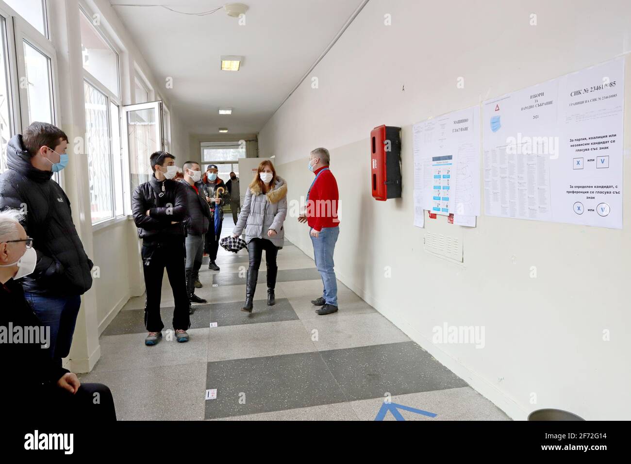 Le persone con maschere votano durante la pandemia di coronavirus per il bulgaro elezioni parlamentari e per la prima volta nella storia con carta e macchin Foto Stock