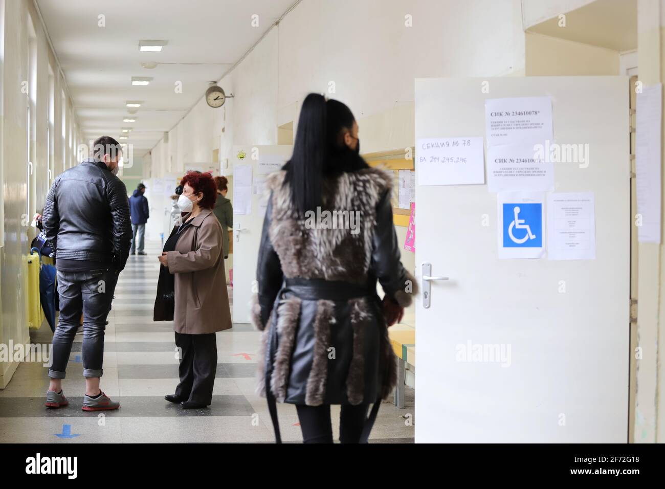 Le persone con maschere votano durante la pandemia di coronavirus per il bulgaro elezioni parlamentari e per la prima volta nella storia con carta e macchin Foto Stock